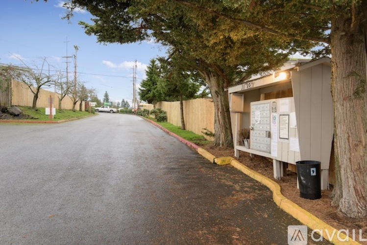 A tree-lined street with a utility box on the side.