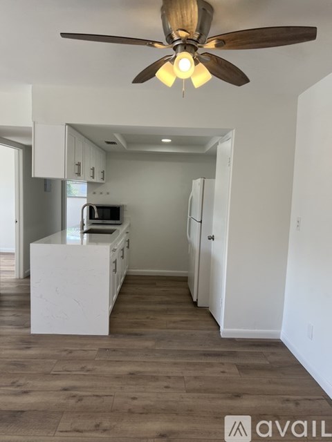 A kitchen with a ceiling fan and a counter.