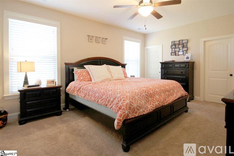 A bedroom with a bed, dresser, and window.
