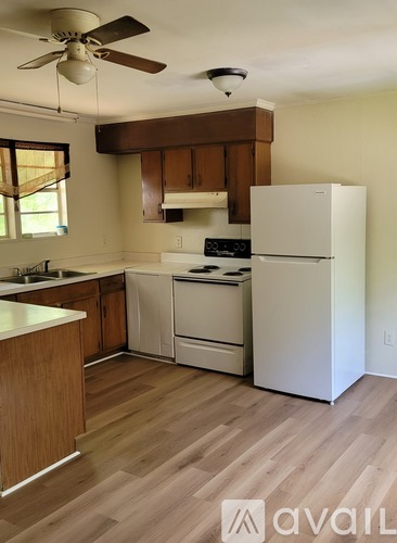 A kitchen with wooden floors and white appliances.