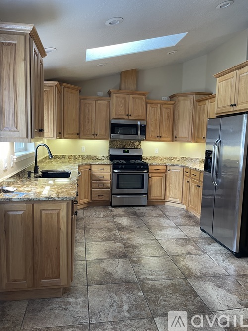A kitchen with wooden cabinets and a tiled floor.
