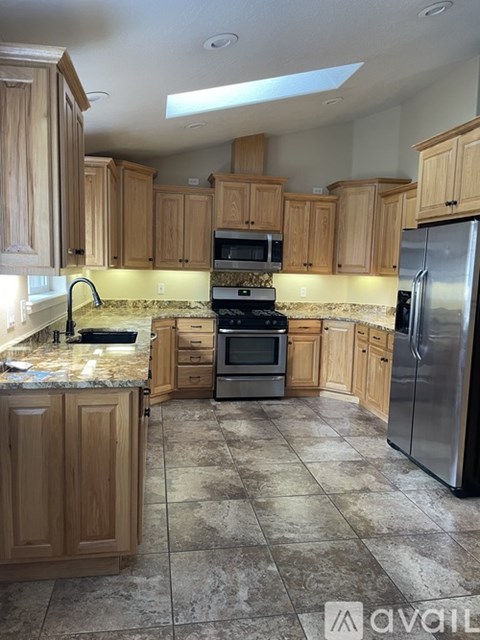 A kitchen with wooden cabinets and a tiled floor.