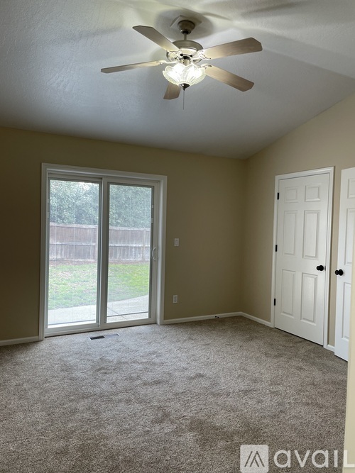 A room with a ceiling fan and a carpeted floor.
