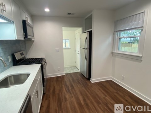 A kitchen with white cabinets and a black stove top oven.