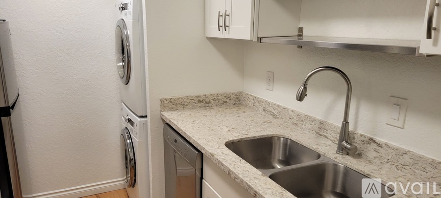 A kitchen with a sink and a washing machine.