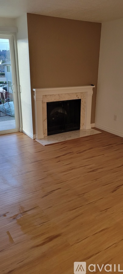 A room with a fireplace and wooden floors.