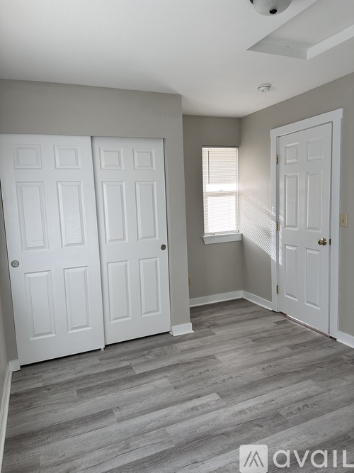A room with two white doors and a window.