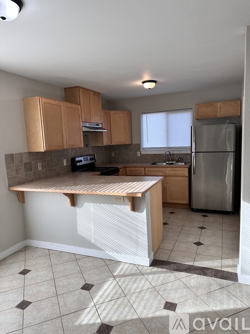 A kitchen with a refrigerator, microwave, and oven.