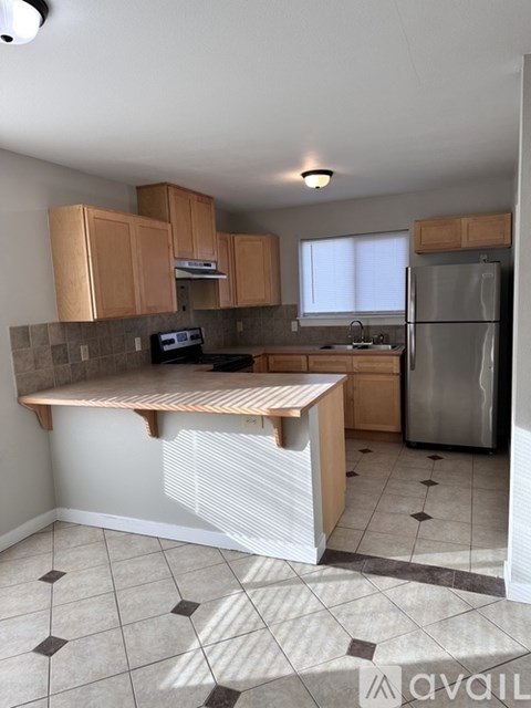 A kitchen with a refrigerator, microwave, and oven.