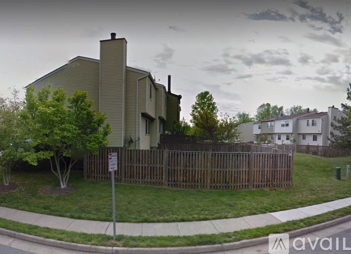 A house with a grey roof and a brown fence.
