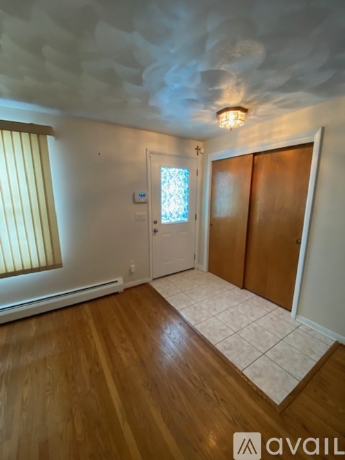 A room with wooden floors and a ceiling with cloud design.