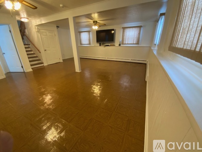 A spacious living room with a staircase and a television.
