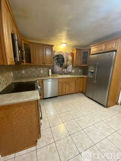 A kitchen with wooden cabinets and a tiled floor.