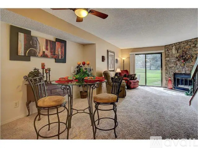 A dining room with a table set for four and a fireplace.