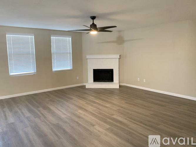 A room with a fireplace and a ceiling fan.