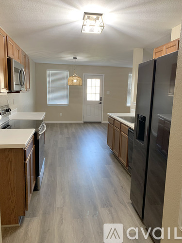 A kitchen with wooden cabinets and a refrigerator.