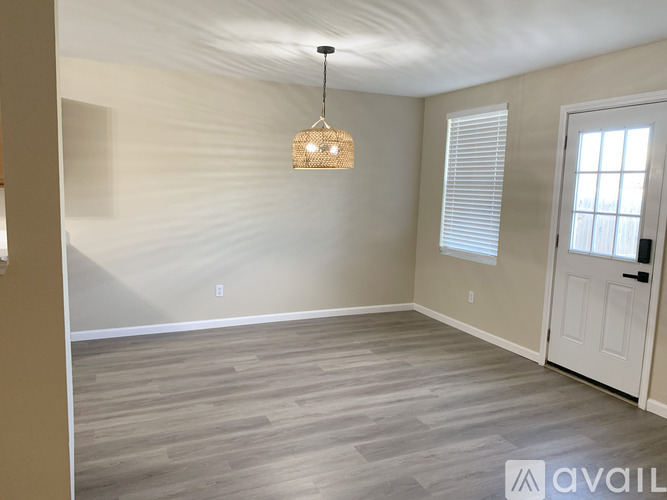 A room with a wooden floor and a white door.
