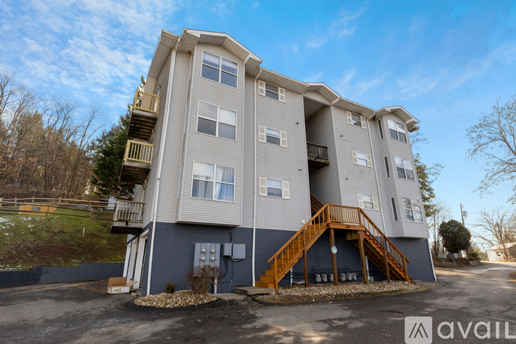 A large apartment building with a blue exterior and a wooden staircase leading to the second floor.
