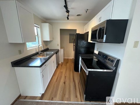 A kitchen with black countertops and white cabinets.