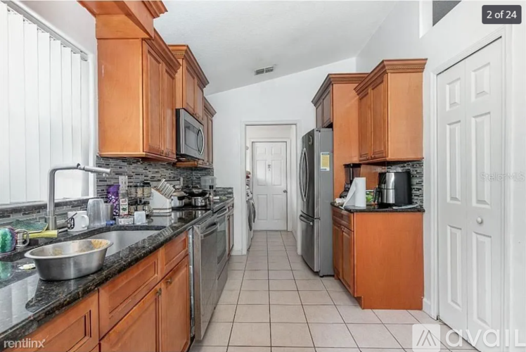 A kitchen with wooden cabinets and a black countertop.