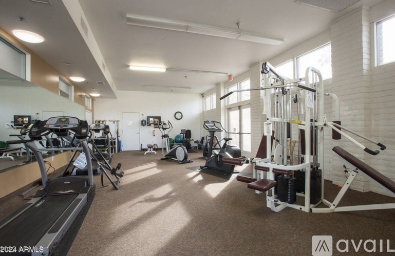 A gym with treadmills, exercise bikes, and weight machines.