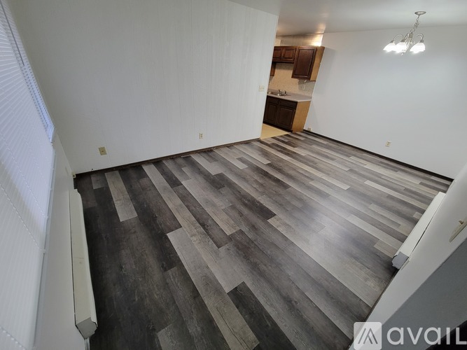 A room with wooden flooring and white walls.