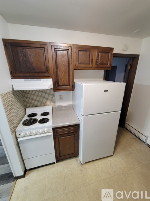 A kitchen with a white fridge and stove top oven.