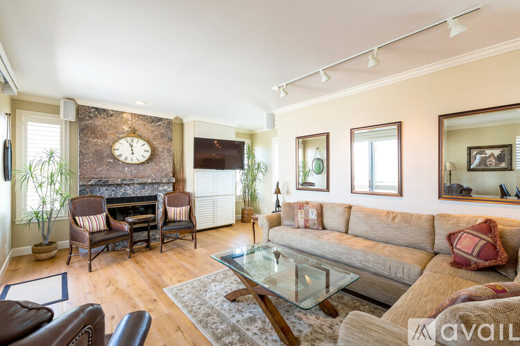 A living room with a fireplace and a large clock on the wall.