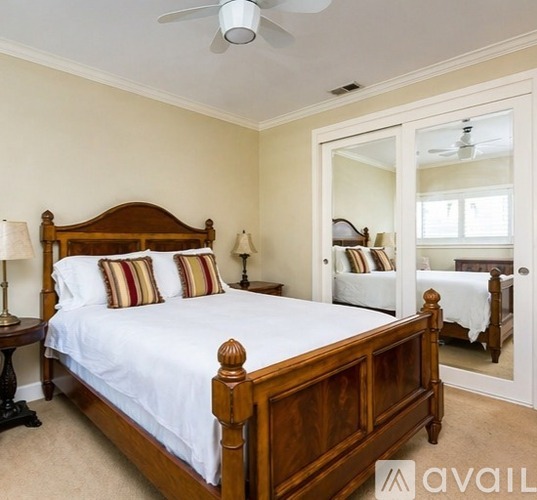A bedroom with a large bed and a ceiling fan.