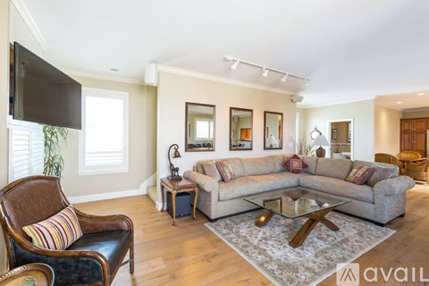 A living room with a brown leather chair and a grey sofa.