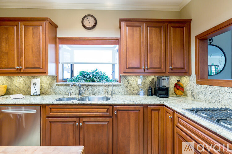 A kitchen with wooden cabinets and a granite countertop.