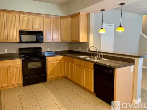 A kitchen with wooden cabinets and black appliances.