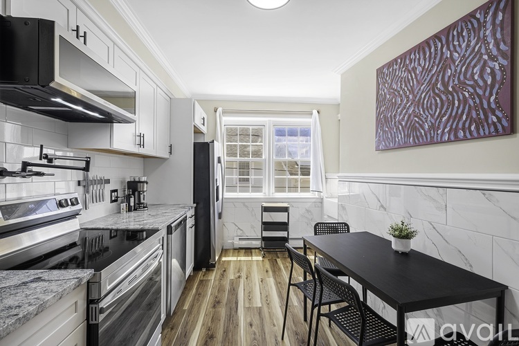 A kitchen with a black table and chairs.