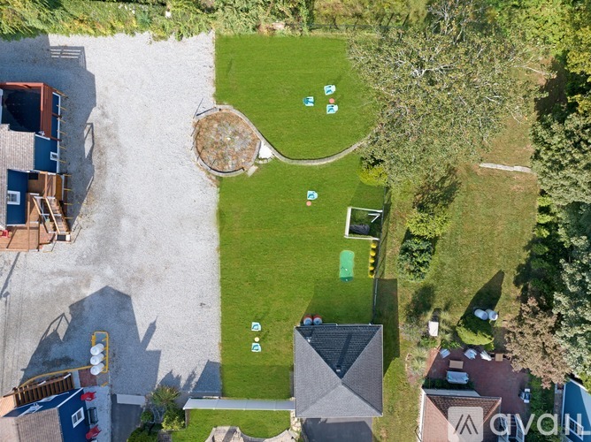 A bird's eye view of a residential area with a large lawn and a small playground.