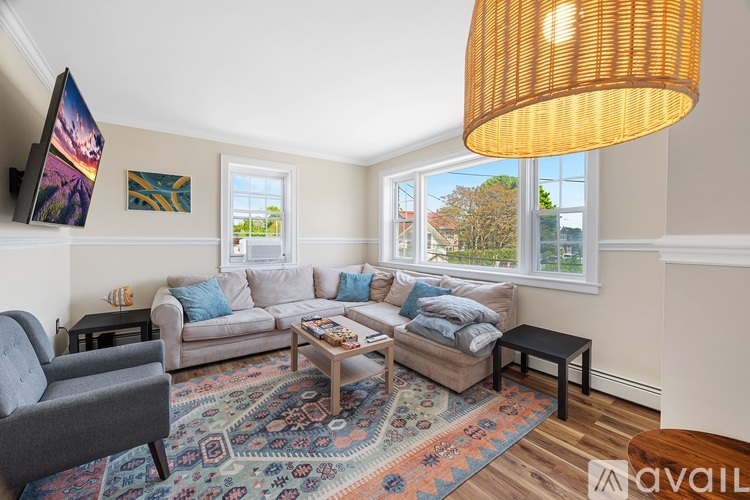 A living room with a grey couch, a coffee table, and a rug with a pattern.