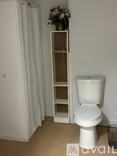 A white toilet is in a room with a white shower curtain.