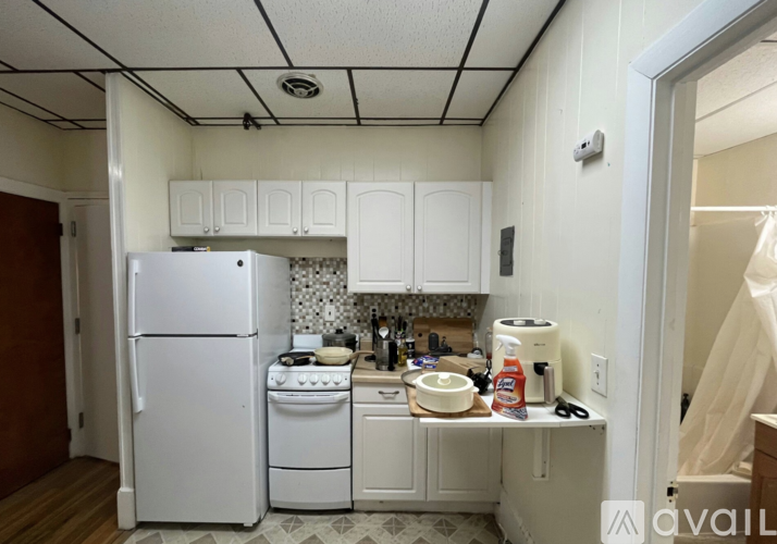 A kitchen with white appliances and cabinets.