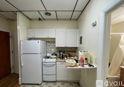A kitchen with white appliances and cabinets.