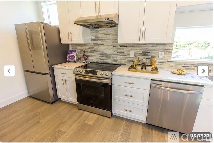 A modern kitchen with a refrigerator, oven, and countertops.