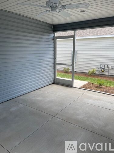 A patio with a sliding glass door and a fan on the ceiling.