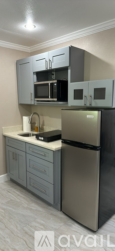 A kitchen with a stainless steel refrigerator and cabinets.