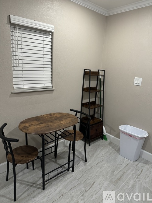 A room with a table, chairs and a window.