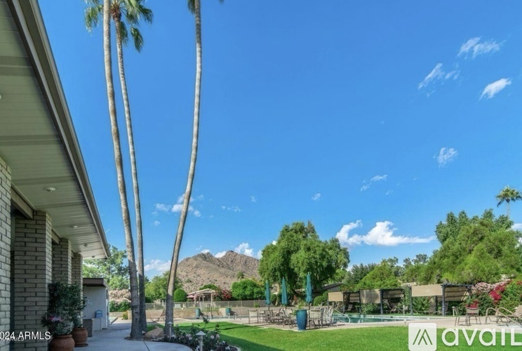 A house with a pool and palm trees in the background.