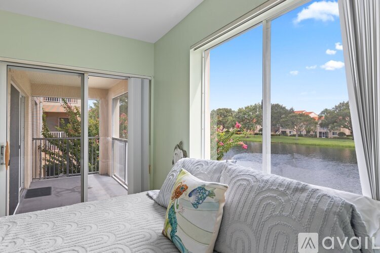 A bedroom with a large bed and a view of a lake through the window.