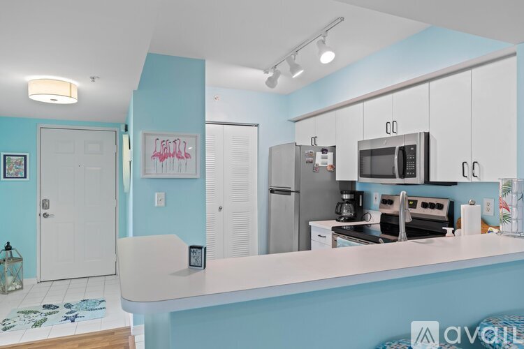 A kitchen with a white counter and a blue wall.