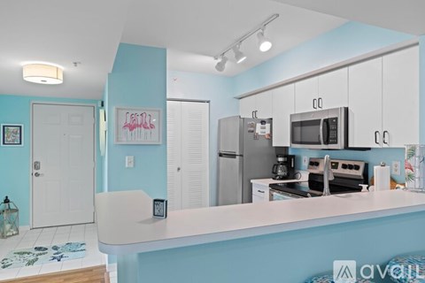 A kitchen with a white counter and a blue wall.