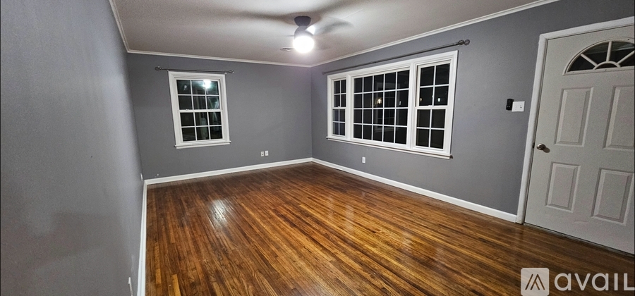A room with wooden floors and a ceiling fan.