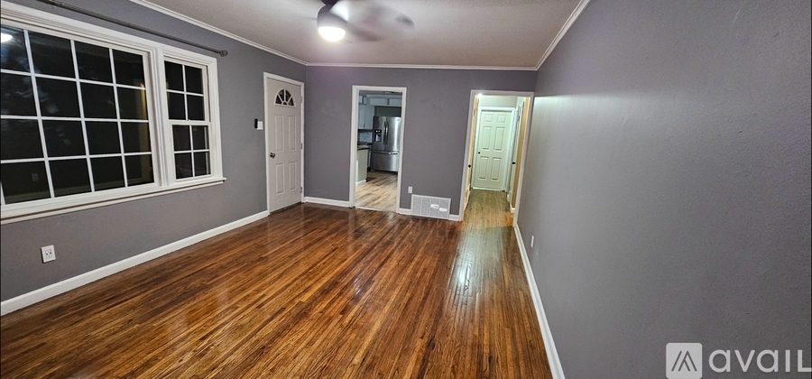 A room with wooden floors and a ceiling fan.