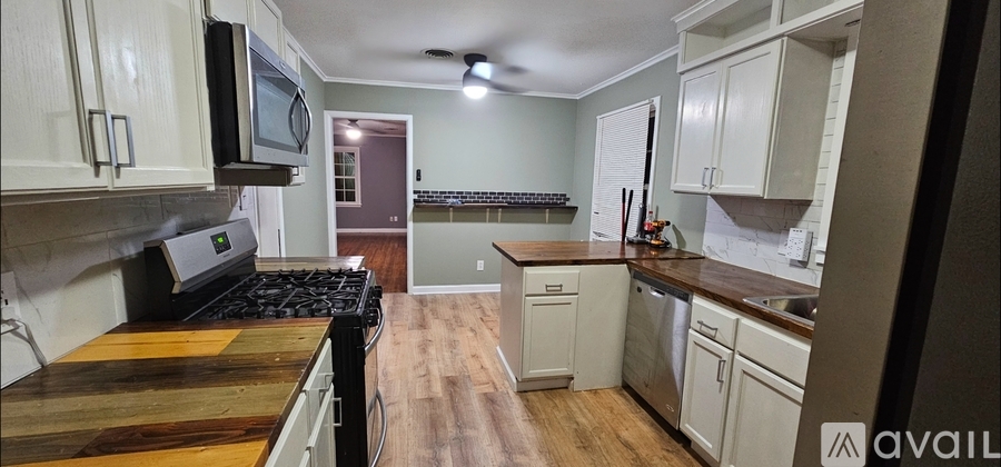 A kitchen with a wooden cutting board on the counter.