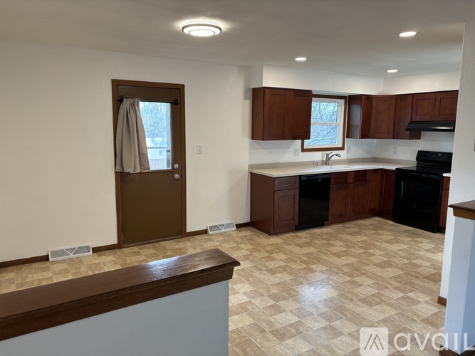 A kitchen with brown cabinets and a checkered floor.
